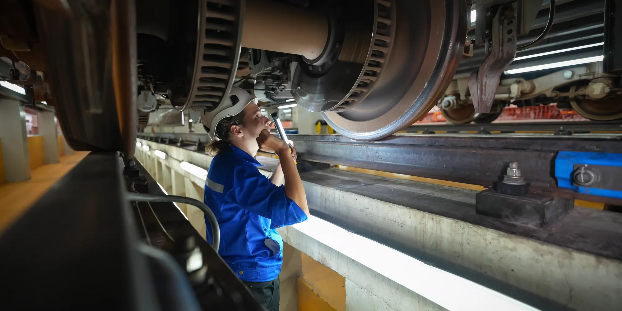 Technicus inspecteert wielen en remschijven van onderaf